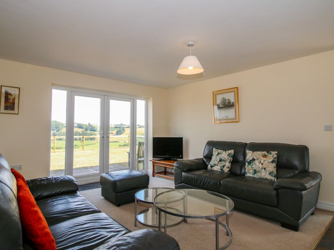 A living room with a television and sofa at Wood Cottage in Tenbury Wells