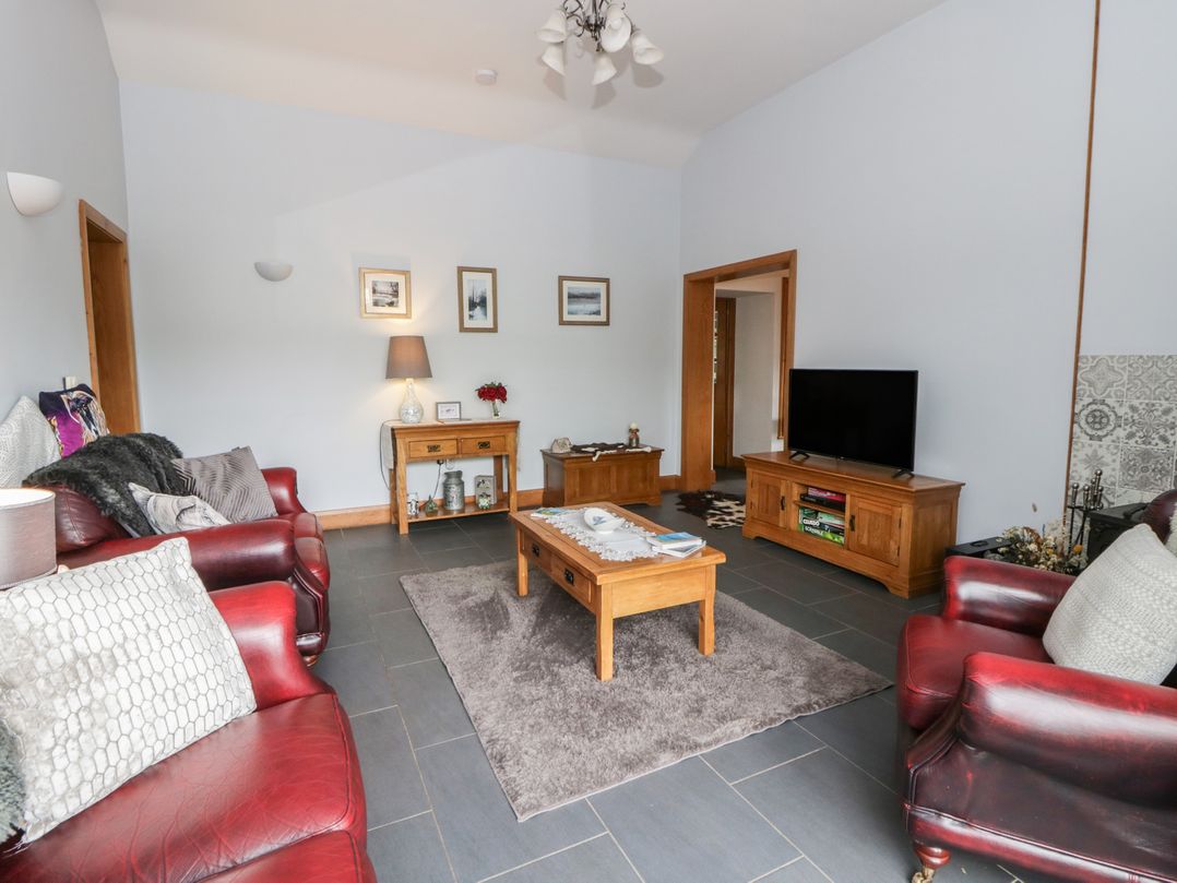 A living room with sofas and a television at Yr Hen Llaethdy in Blaen-Cil-Llech near Newcastle Emlyn