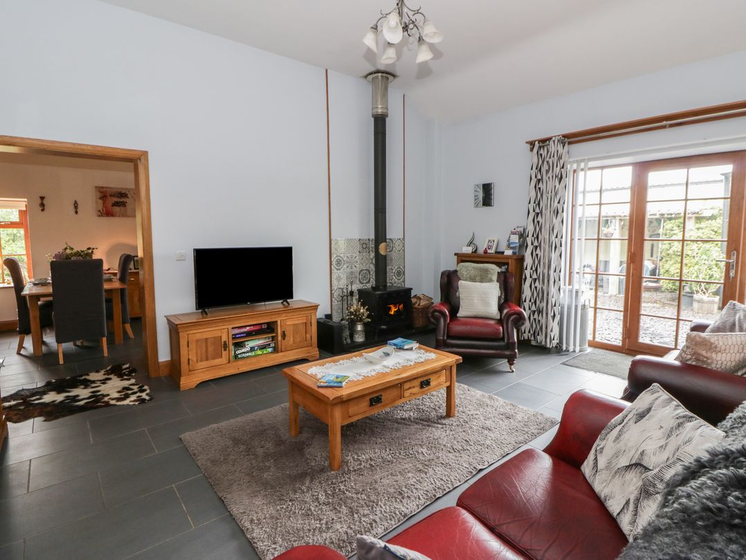 A living room with a sofa, coffee table, and fireplace at Yr Hen Llaethdy near Blaen-Cil-Llech near Newcastle Emlyn