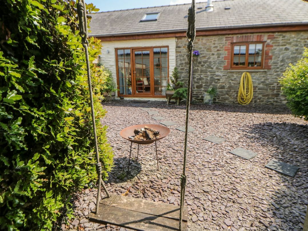 An outdoor area with a swing and fire pit at Yr Hen Llaethdy in Blaen-Cil-Llech near Newcastle Emlyn
