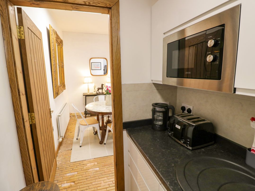 A kitchen with appliances and a door leading to a dining area at Diamond Lodge Ingestre near Great Haywood