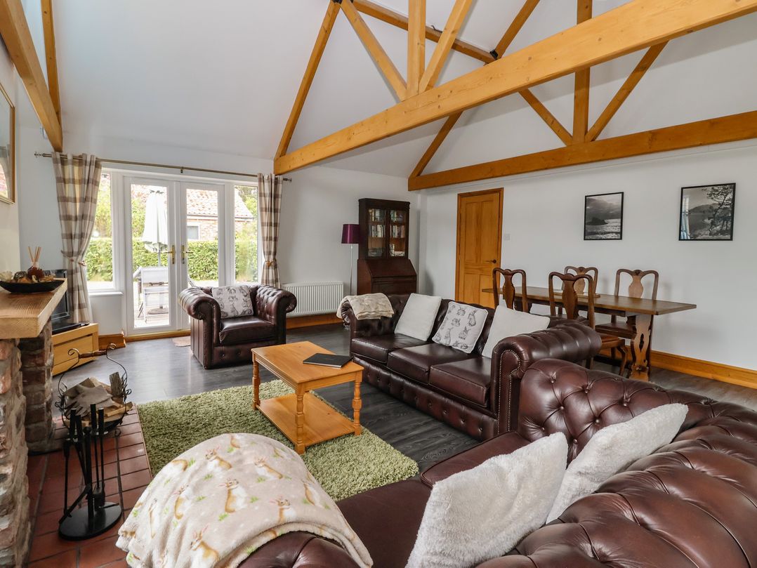A living room with sofa and dining area at Lillieput Lodge Melbourne