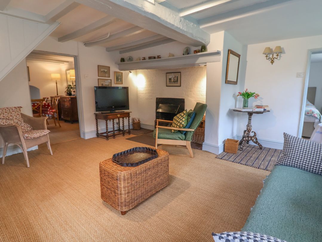 A living room with a television and fireplace at Wolvesacre Mill Cottage Agden near Whitchurch