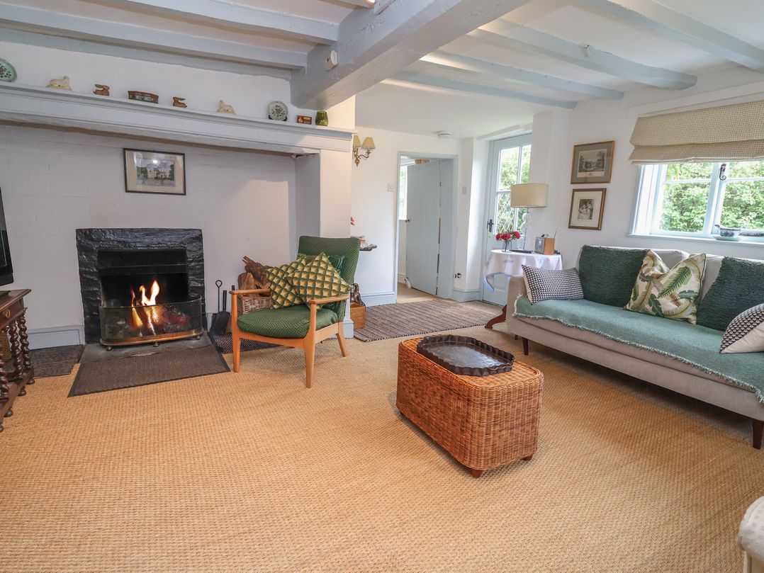 A living room with a fireplace and sofa at Wolvesacre Mill Cottage Agden near Whitchurch