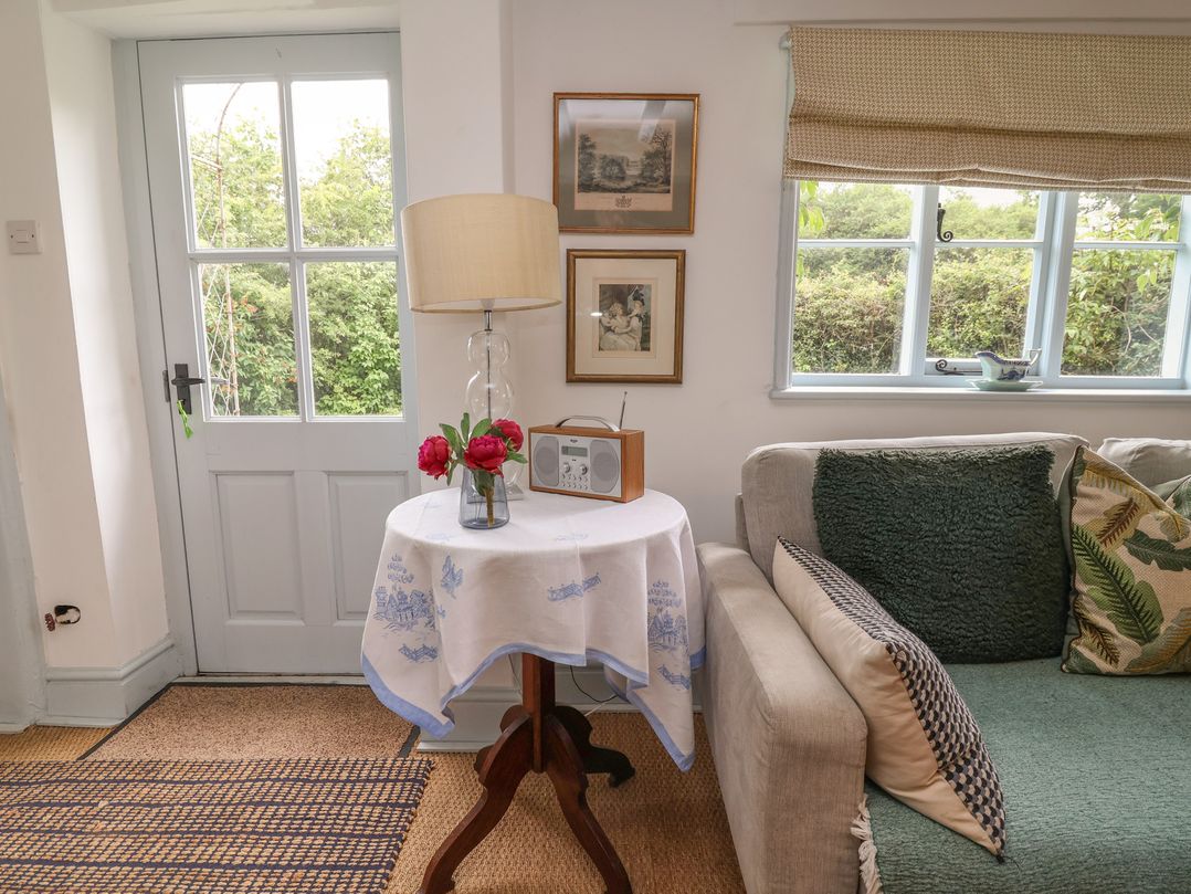 A living room with a table and radio at Wolvesacre Mill Cottage Agden near Whitchurch