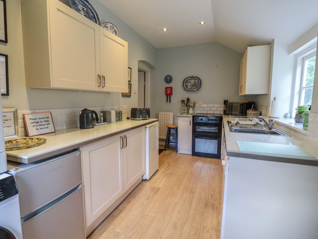 A kitchen with appliances and countertop at Wolvesacre Mill Cottage in Agden near Whitchurch