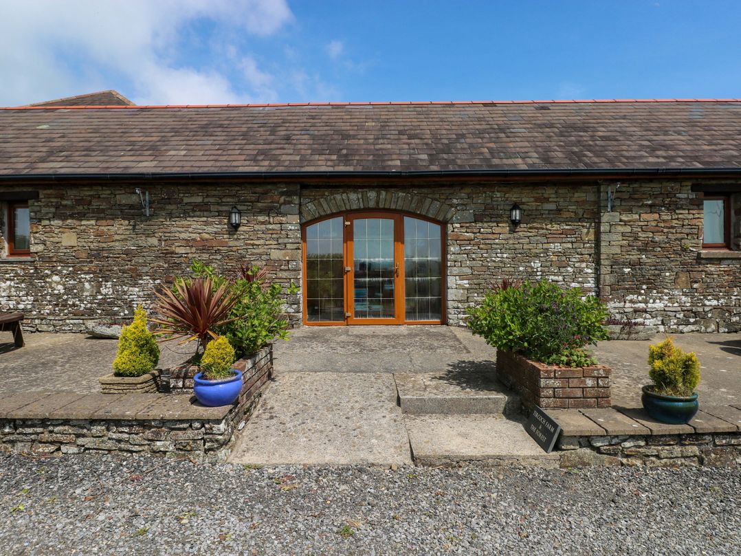An entrance with double doors and potted plants at The Dairy in Penuel near Llanmorlais