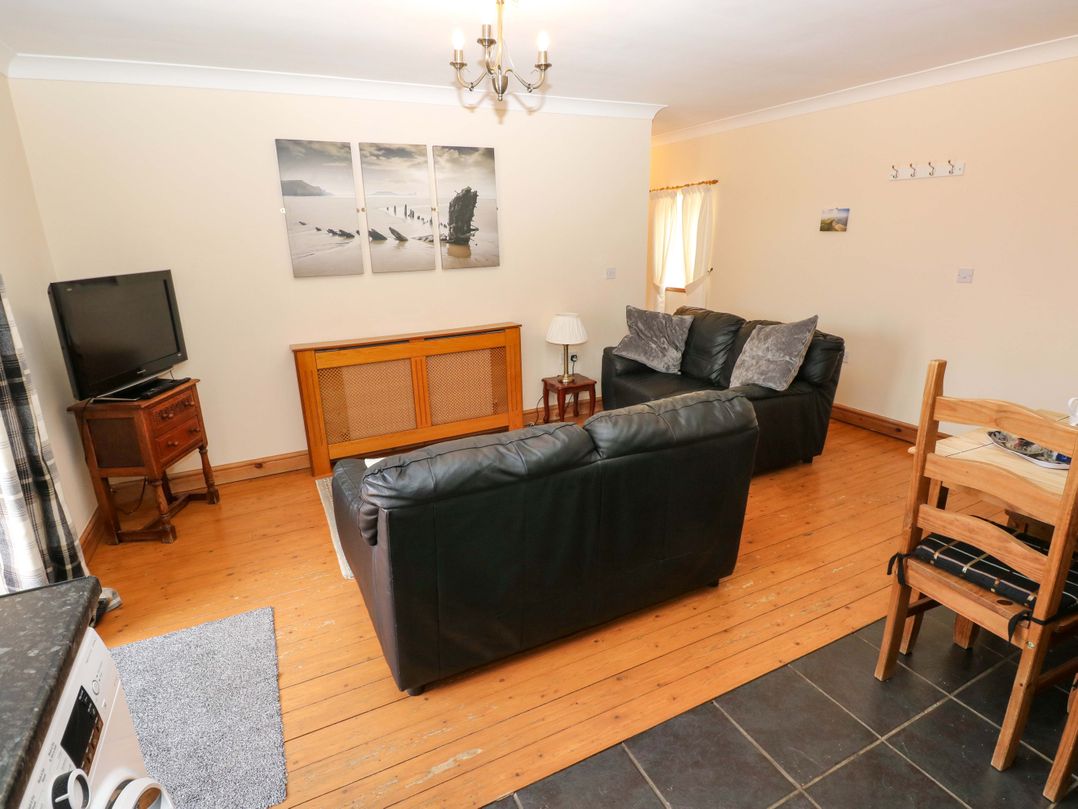 A living room with a television and seating area at The Dairy in Penuel near Llanmorlais