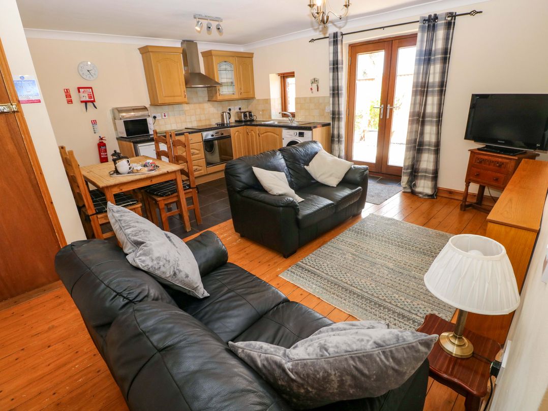 A living room with dining area and kitchen appliances at The Dairy in Penuel near Llanmorlais