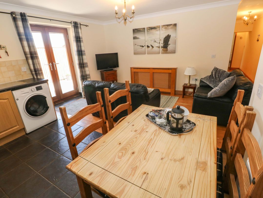 A living room with a dining table and sofa at The Dairy in Penuel near Llanmorlais