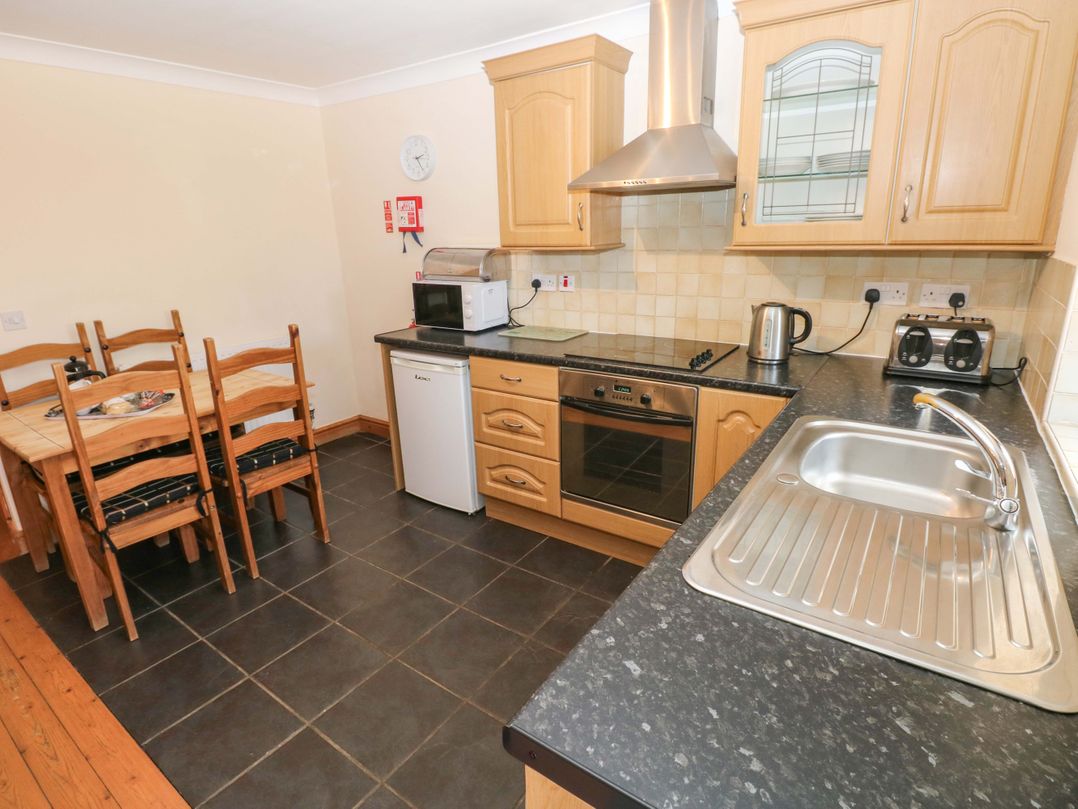 A kitchen with a table and chairs at The Dairy in Penuel near Llanmorlais