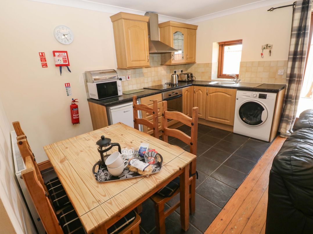 A kitchen with a table and chairs at The Dairy in Penuel near Llanmorlais