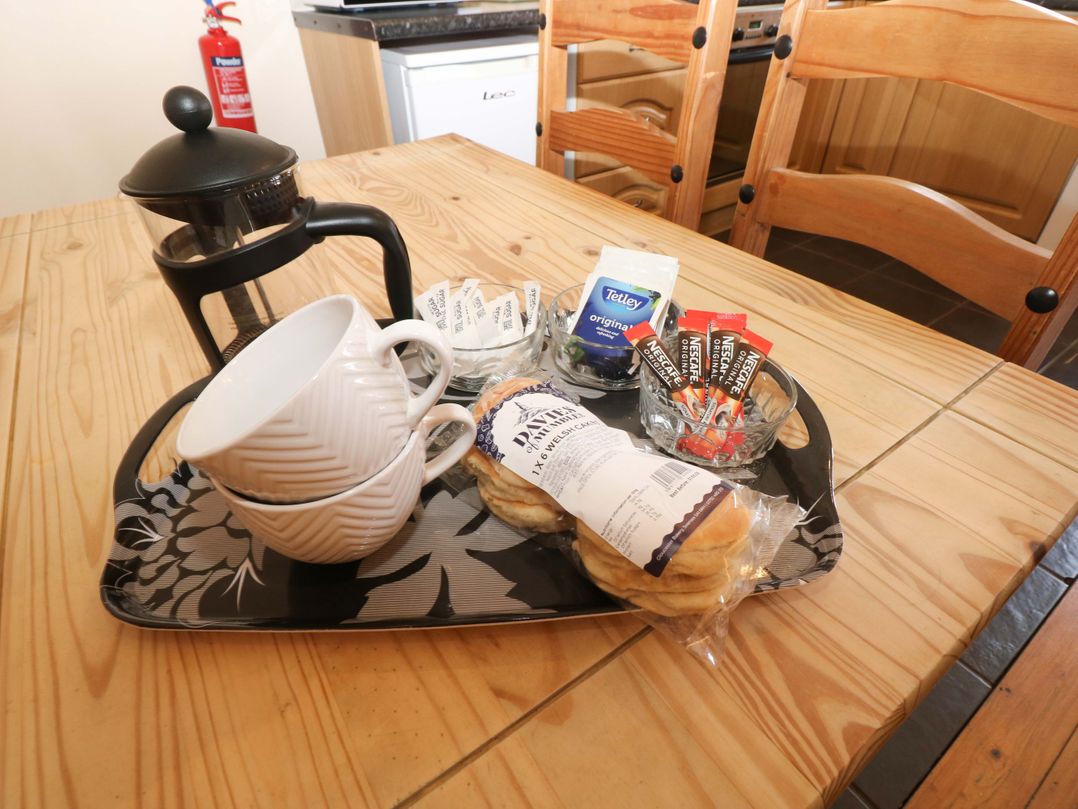 A kitchen table with a tray containing mugs, a coffee pot, biscuits and tea at The Dairy in Penuel near Llanmorlais