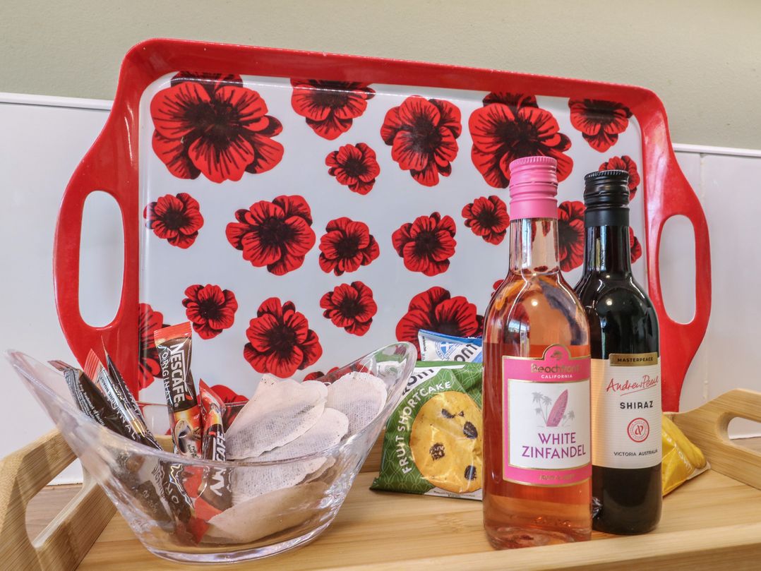 A tray with wine bottles and snacks at Steam Cottage in Aviemore