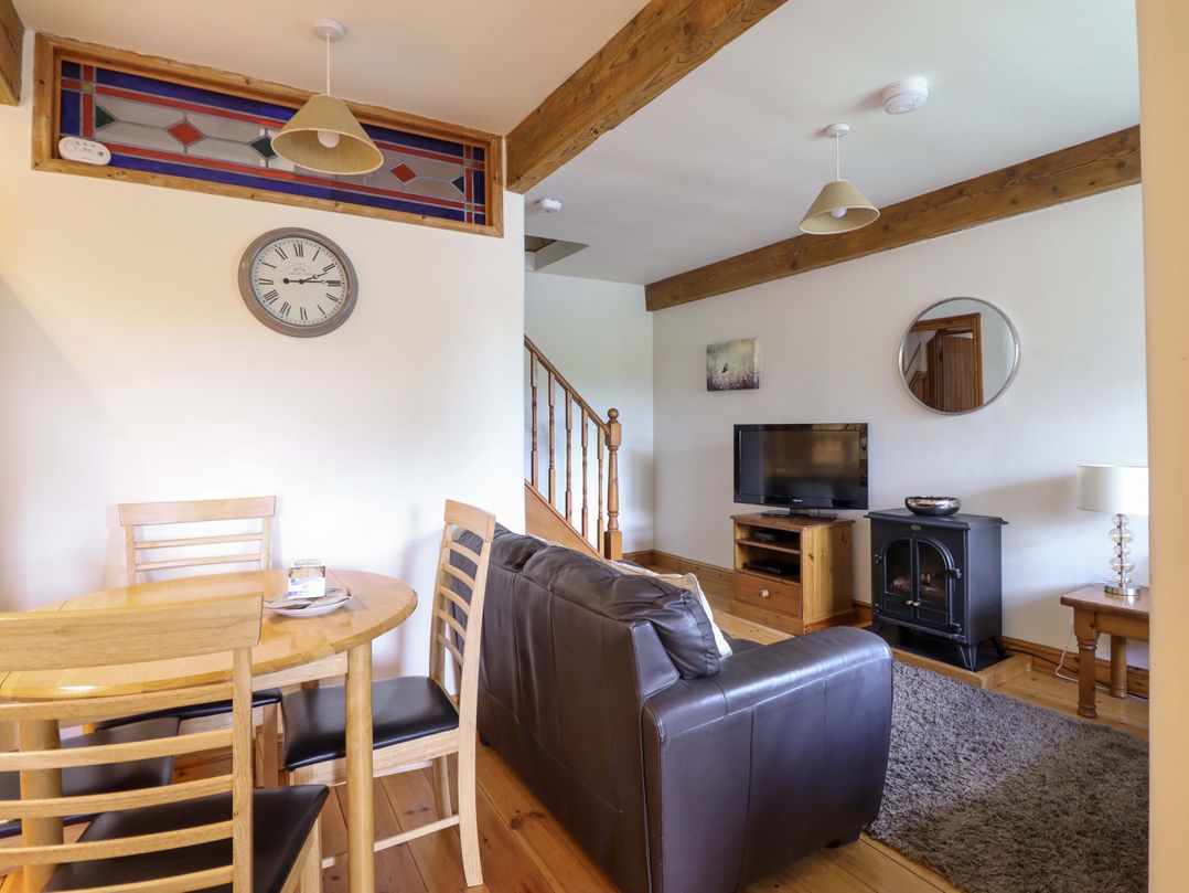 A living room with a sofa and television at Stabal Cottage Dolgellau