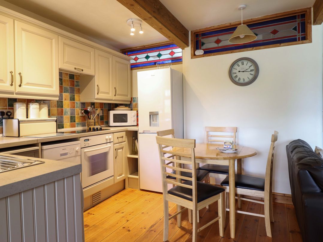 A kitchen with a table and chairs at Stabal Cottage in Dolgellau
