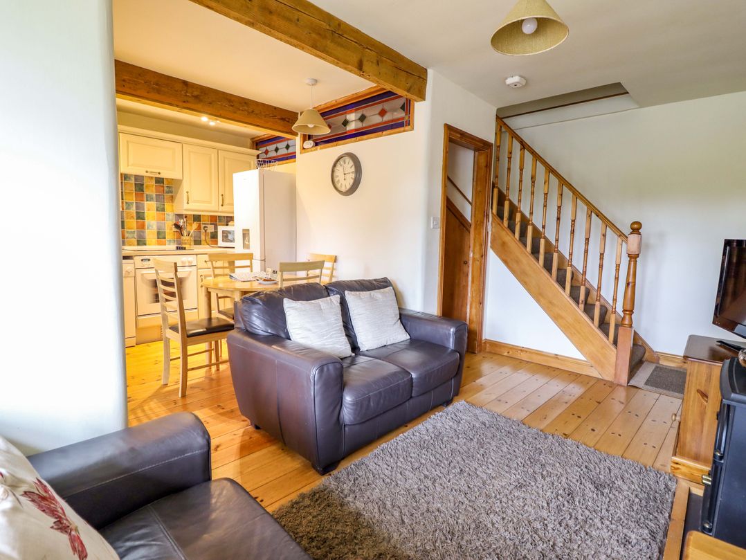 A living room with a sofa and dining area at Stabal Cottage in Dolgellau