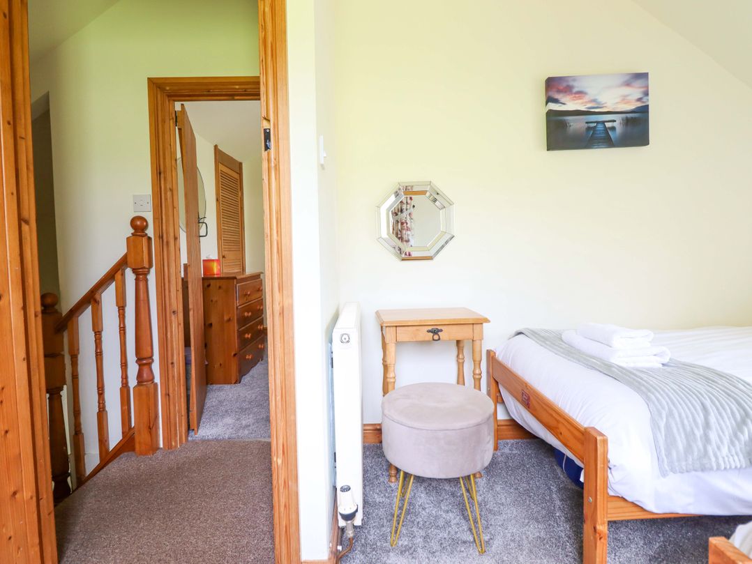 A bedroom with a bed and bedside table at Stabal Cottage in Dolgellau