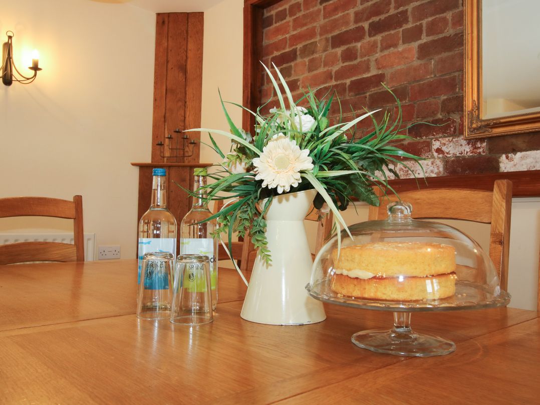 A dining room table with flowers, cake, water bottles, and glasses at Trooper's Barn Westhope