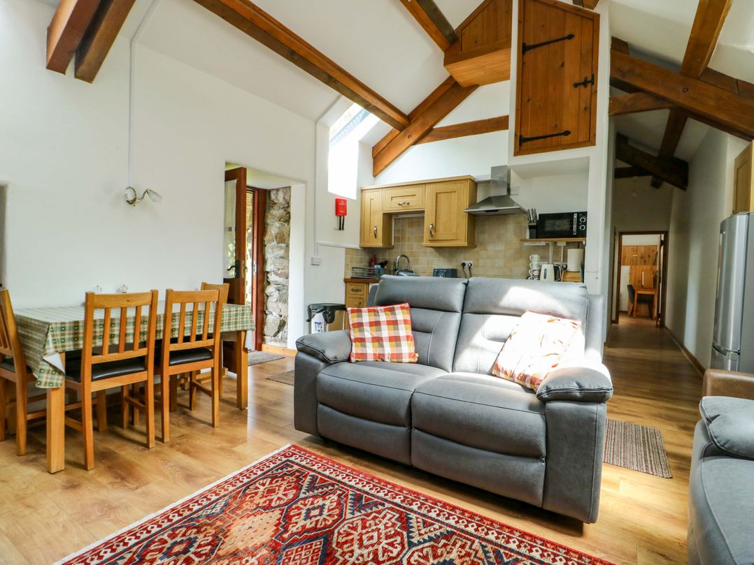 A living room with a sofa and dining area at Bythyn Ddol Hafod in Capel Curig