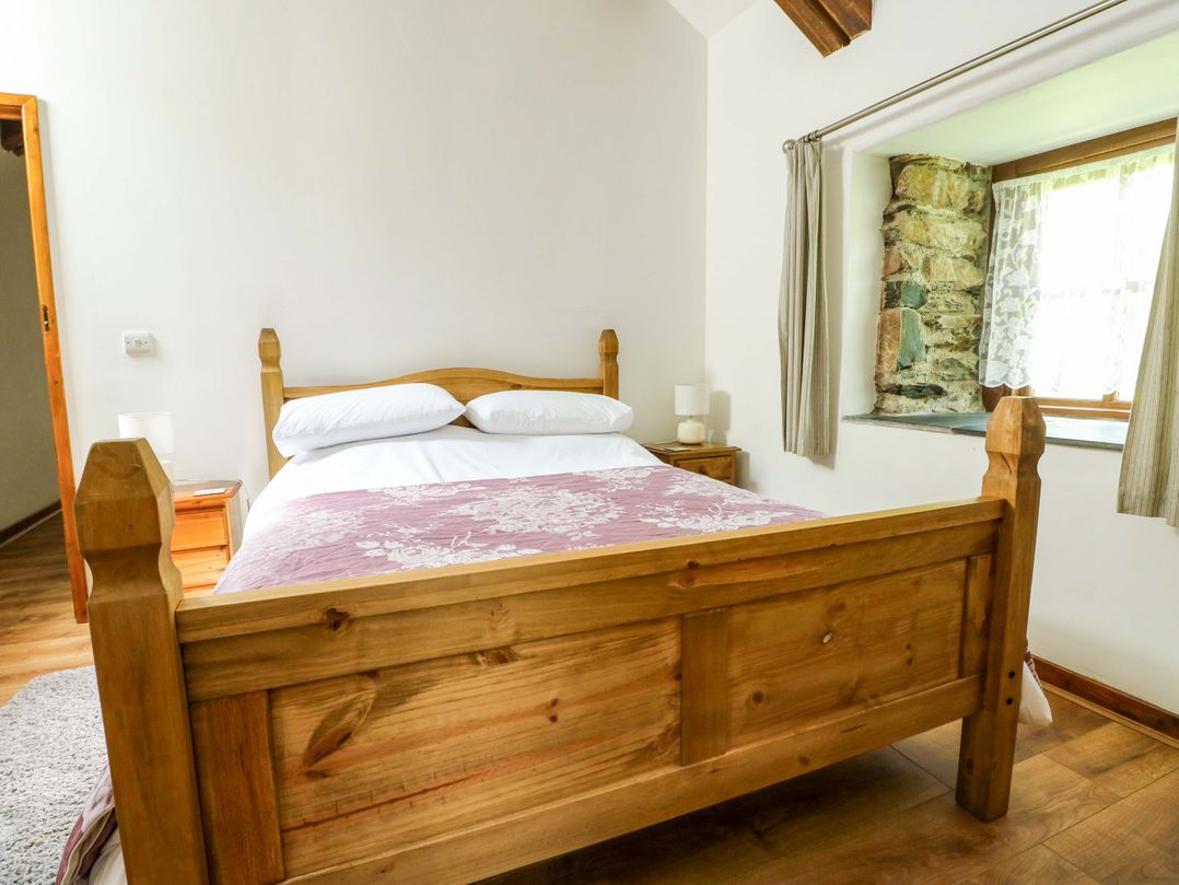 A bedroom with a bed and bedside table at Bythyn Ddol Hafod in Capel Curig