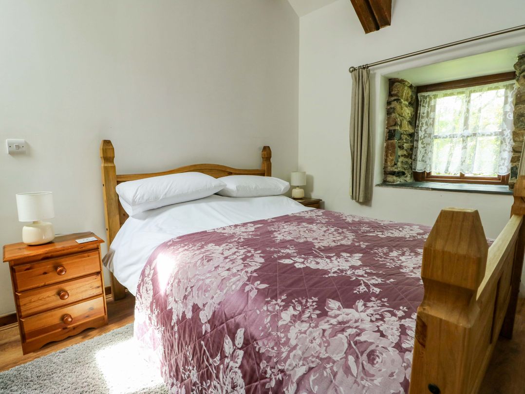 A bedroom with a bed and bedside table at Bythyn Ddol Hafod in Capel Curig