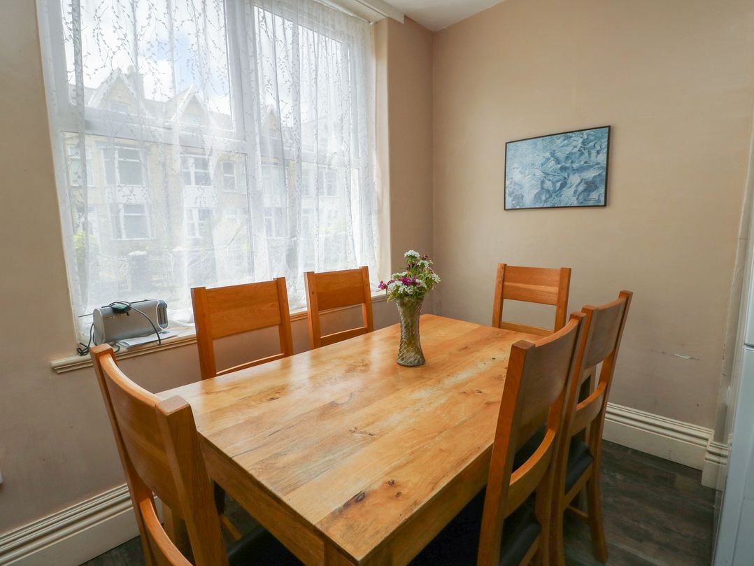 A dining room with a wooden table and chairs at Halford Hill in Llanberis