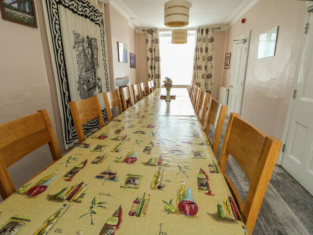 A dining room with a large table and wooden chairs at Halford Hill in Llanberis