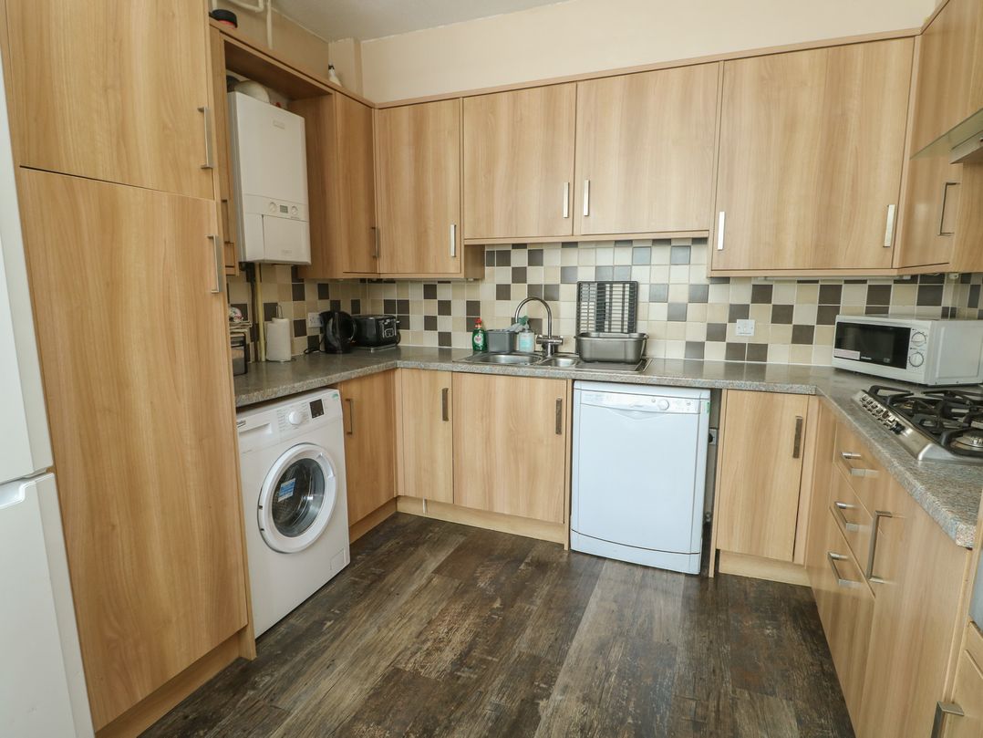 A kitchen with wood cabinets and appliances at Halford Hill in Llanberis