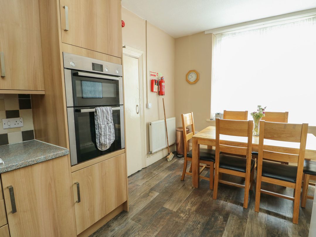 A kitchen with an oven and dining table at Halford Hill in Llanberis
