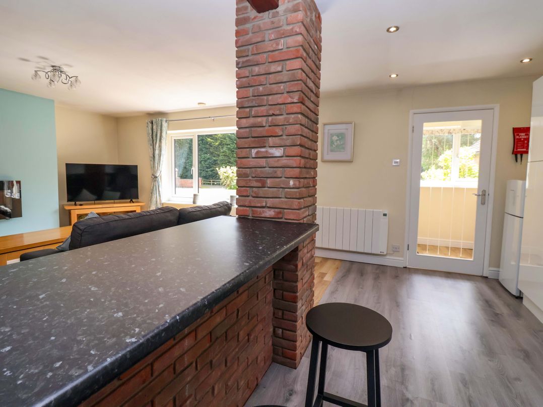 A living room with a bar stool and television at The Granary in York