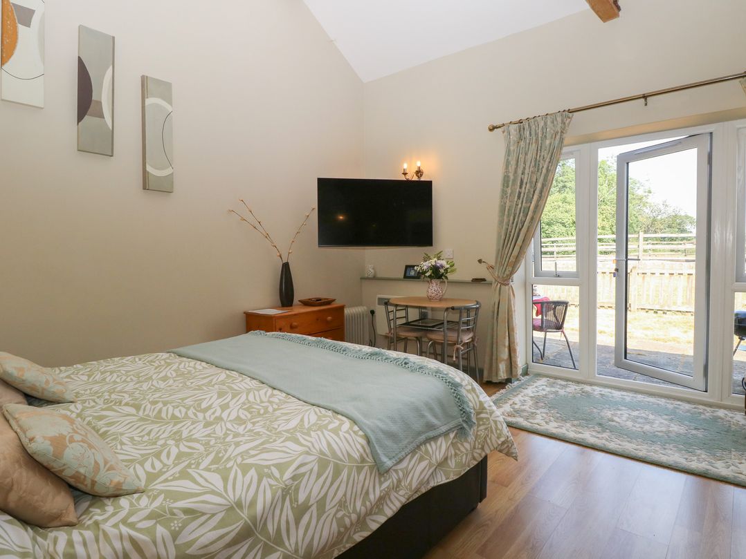 A bedroom with a bed and table at Tawny Owl Barn Shipdham near Dereham