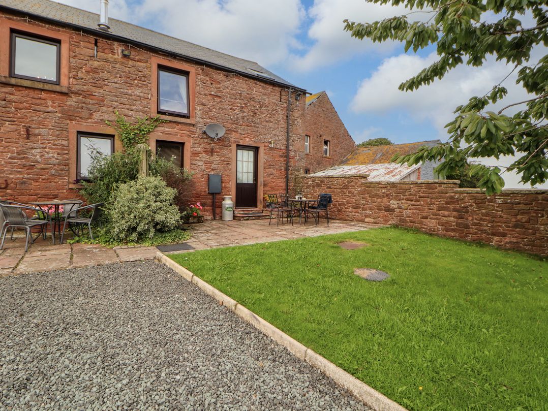 An outdoor area with a building, table, and chairs at Stable Cottage in Bolton Low Houses