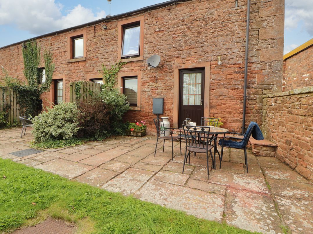An outdoor patio area with a table and chairs at Stable Cottage Bolton Low Houses