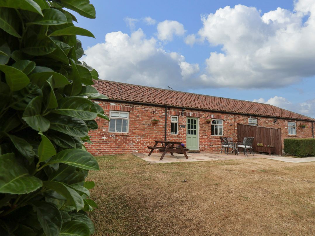 A brick building with a table and chairs outside at Beacon in Gerrick near Moorsholm