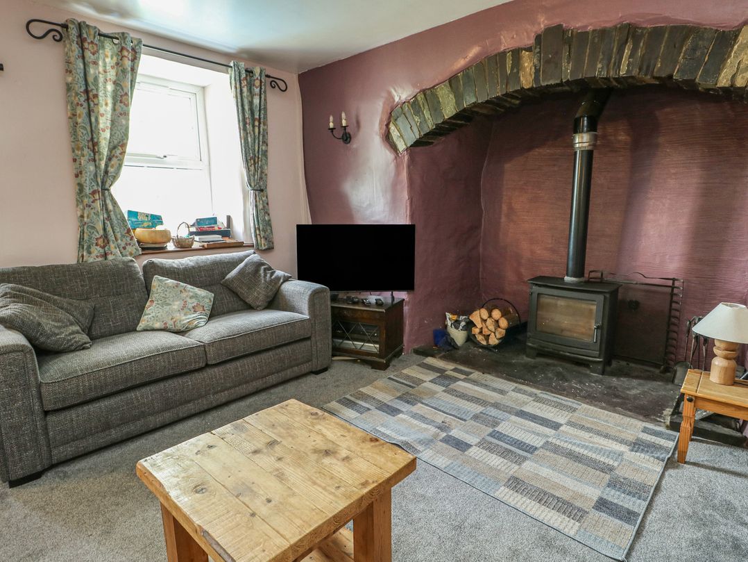A living room with a sofa and coffee table at Glan y Gors in Dinorwic near Llanberis
