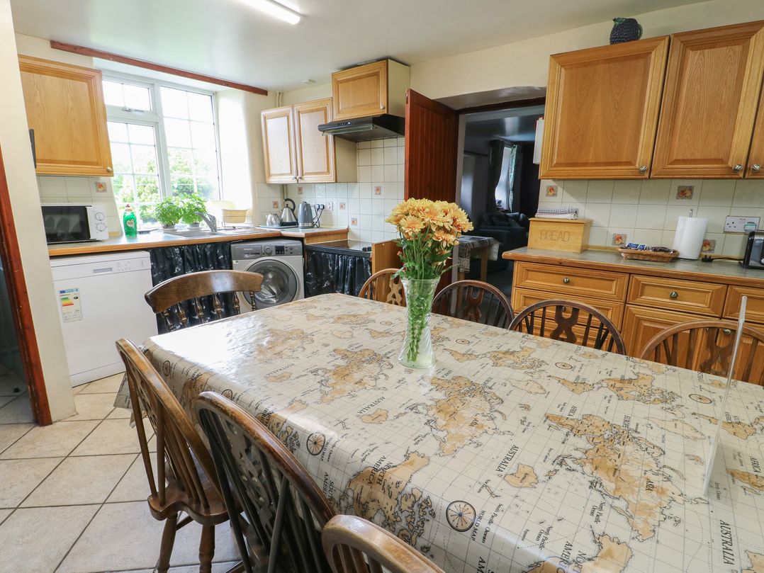 A kitchen with a table and chairs at Glan y Gors in Dinorwic near Llanberis