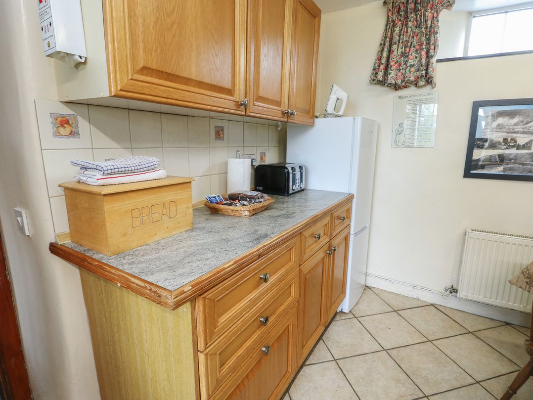 A kitchen with cabinets, countertop, and appliances at Glan y Gors in Dinorwic near Llanberis