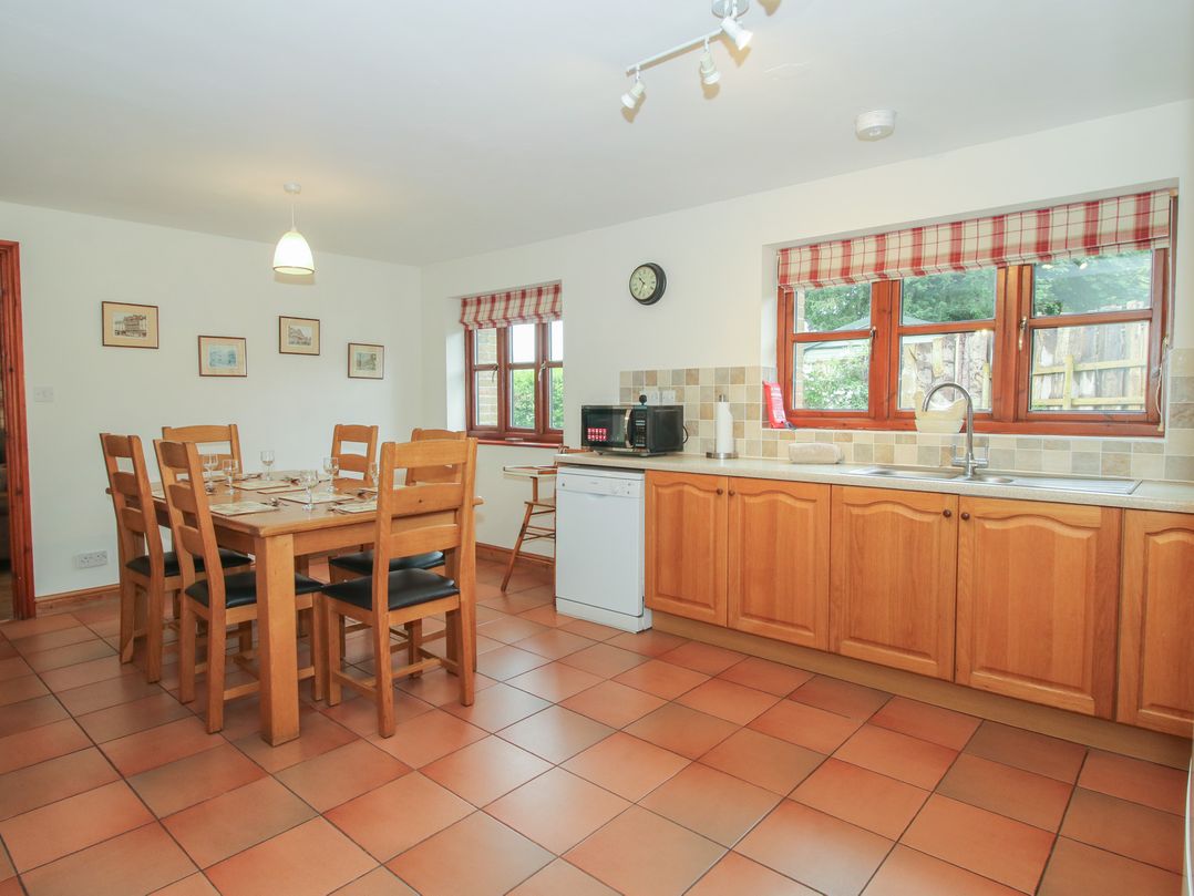 A kitchen with a dining table and chairs at Byne Brook Cottage Strefford near Craven Arms