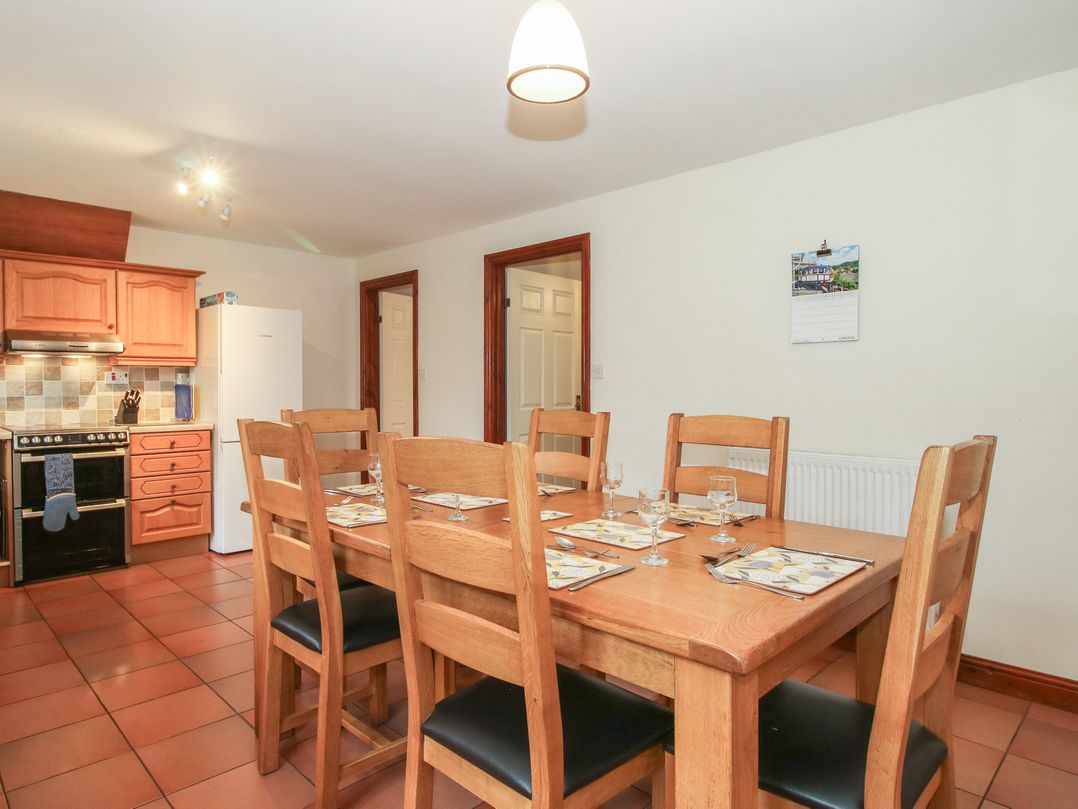 A dining room with a wooden table and chairs at Byne Brook Cottage in Strefford near Craven Arms