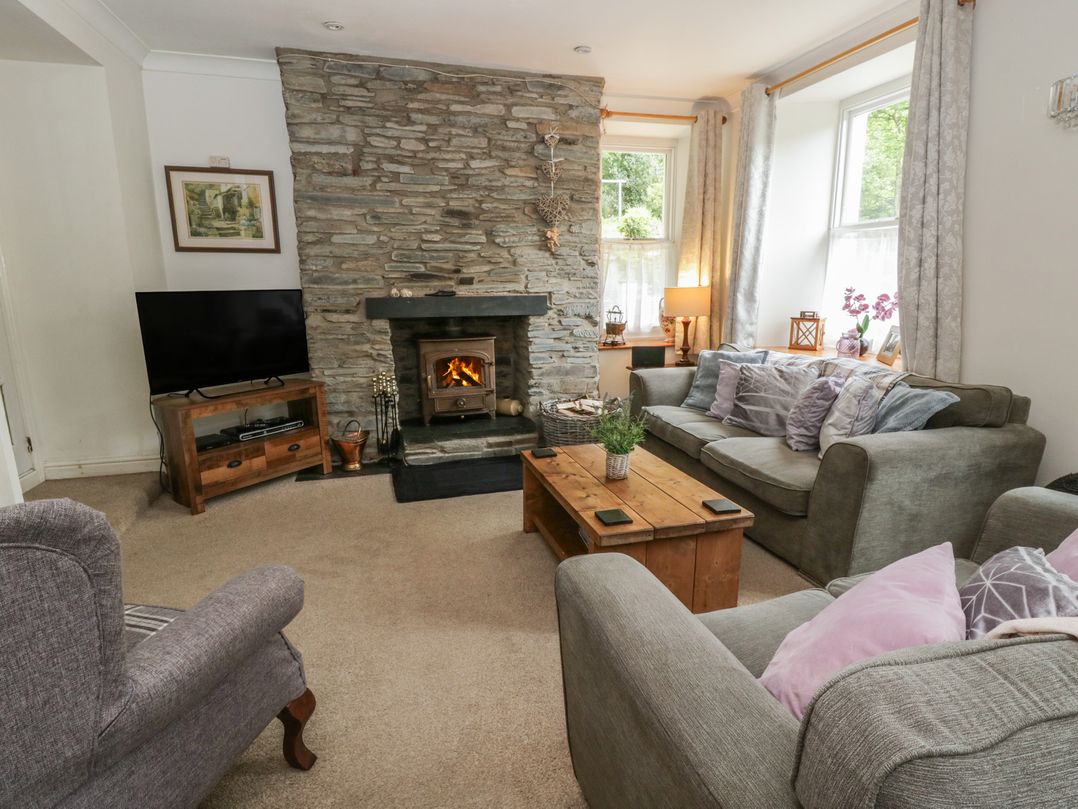 A living room with a stone fireplace and sofas at Teifi House in Cilgerran near Cardigan