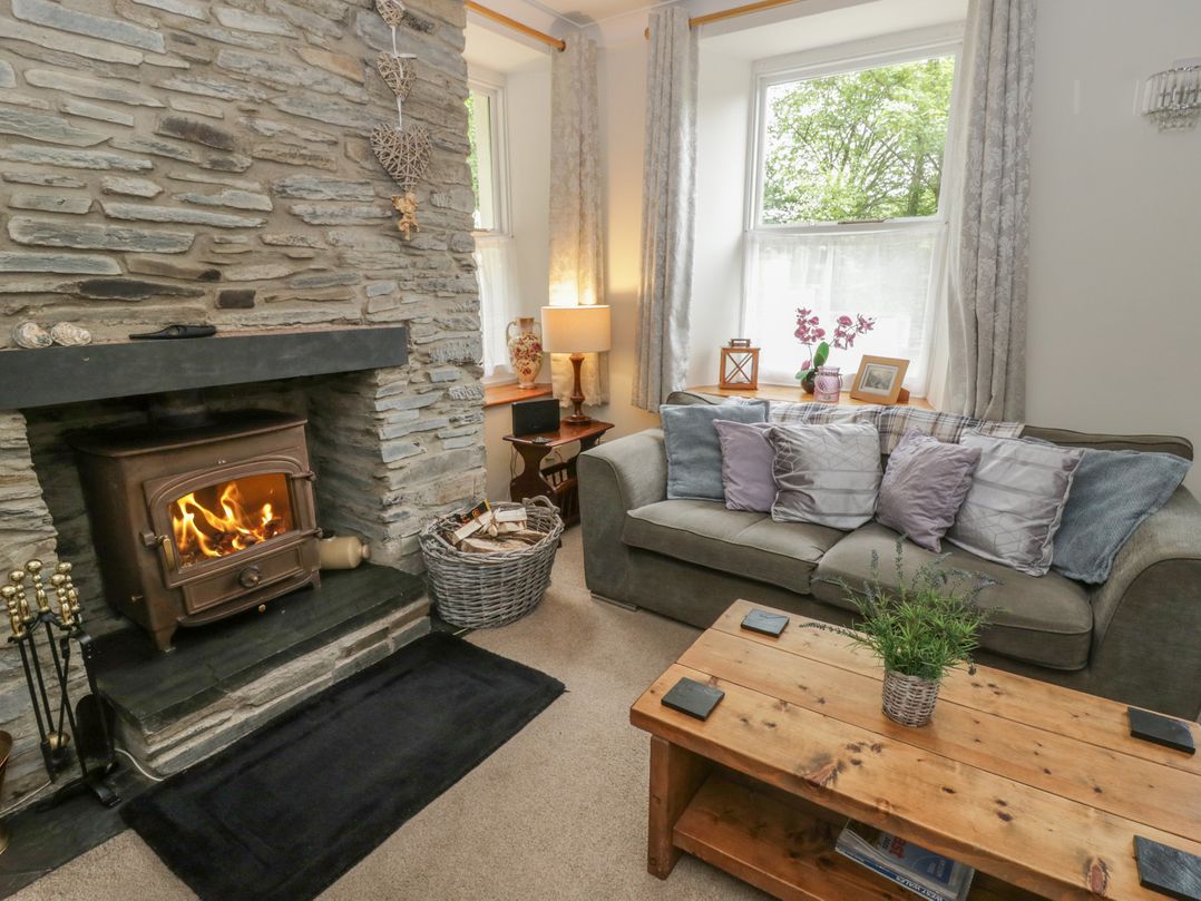 A living room with a fireplace and sofa at Teifi House in Cilgerran near Cardigan