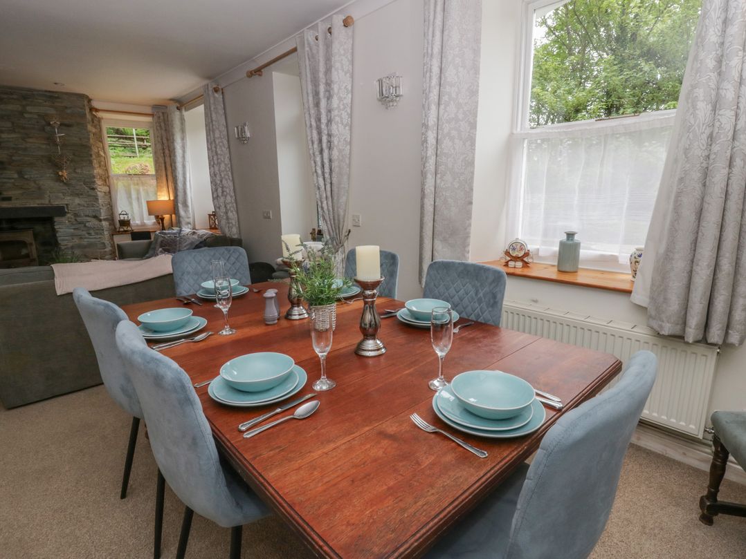 A dining room with a wooden table set for a meal at Teifi House in Cilgerran near Cardigan