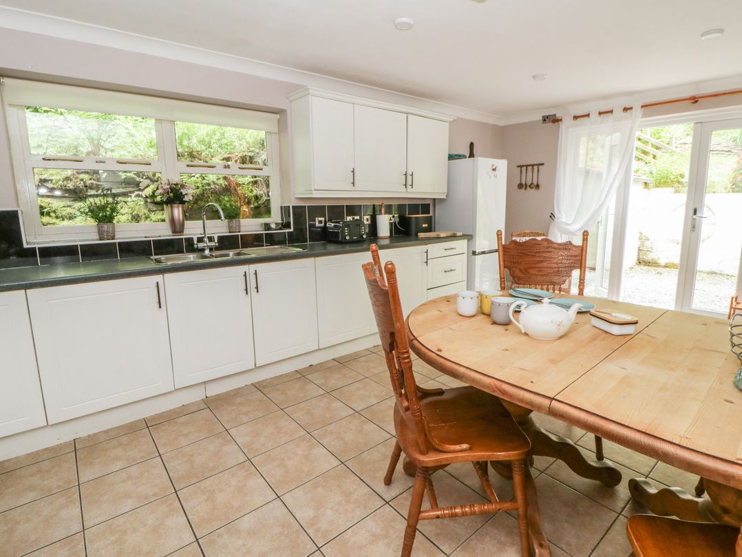 A kitchen with a dining table and chairs at Teifi House in Cilgerran near Cardigan
