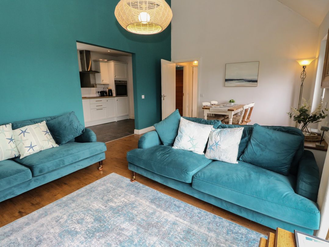 A living room with sofas and a dining area at Starfish Cottage Craignure, Isle Of Mull