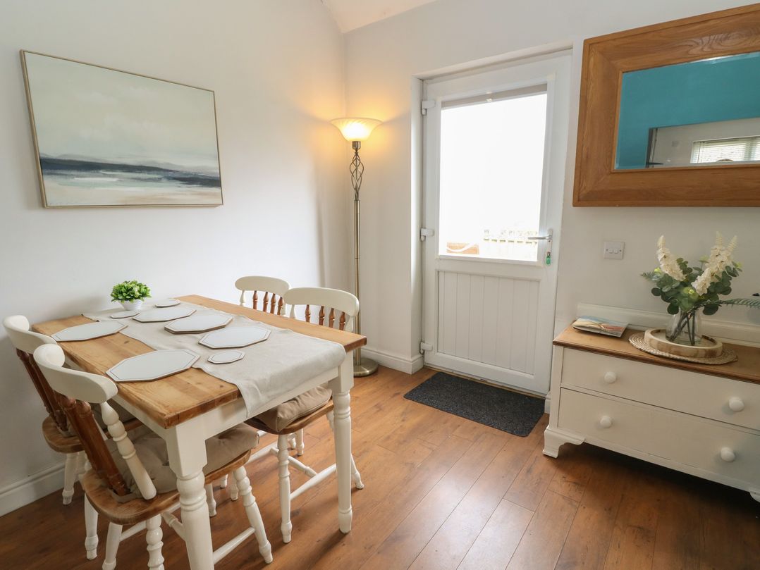 A dining room with a table and chairs at Starfish Cottage in Craignure, Isle Of Mull