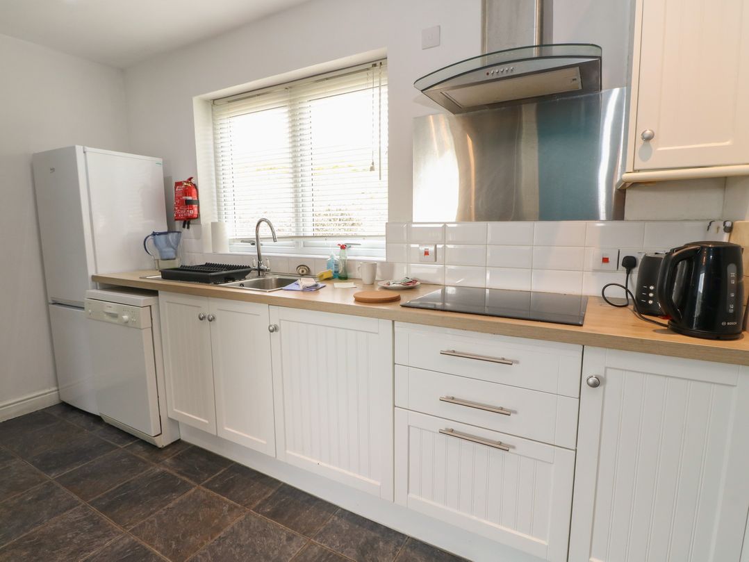 A kitchen with a refrigerator and sink at Starfish Cottage, Craignure, Isle Of Mull