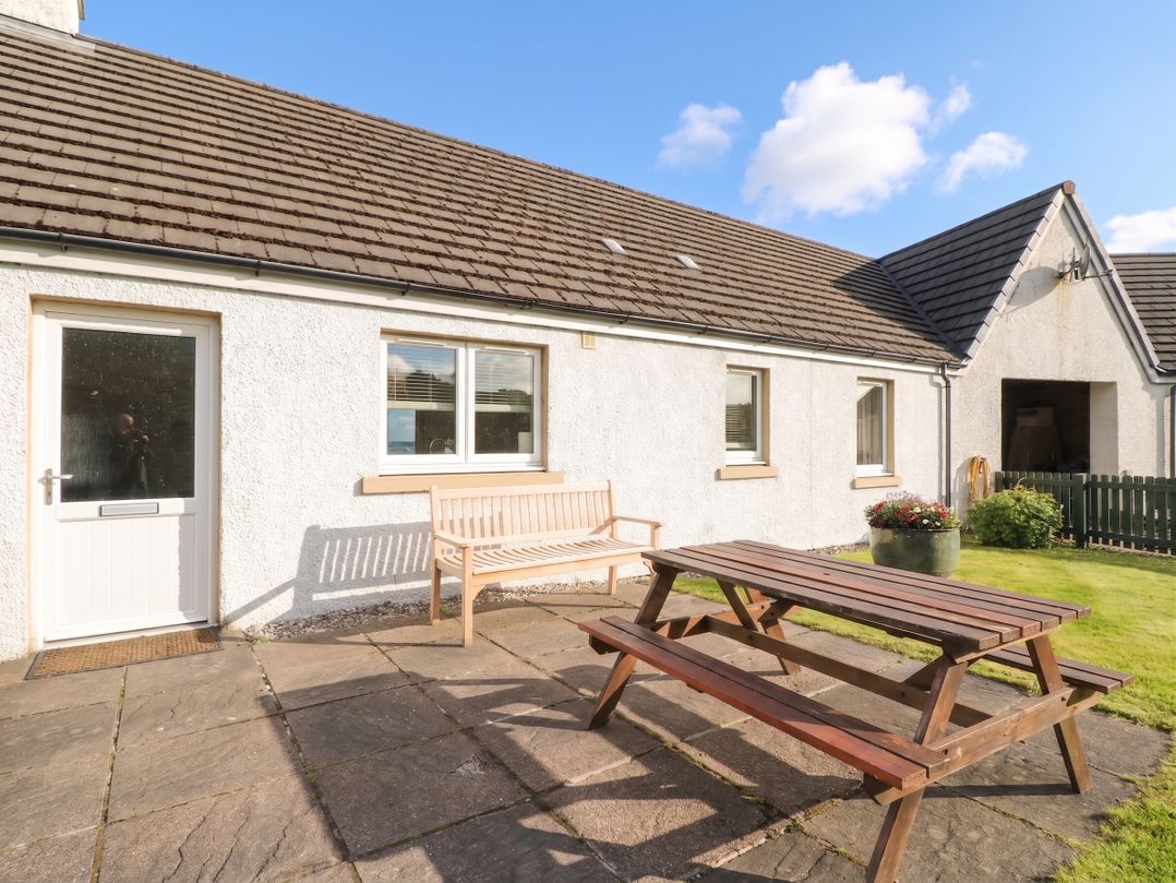 An outdoor area with a picnic table and bench at Driftwood Cottage Craignure Isle Of Mull
