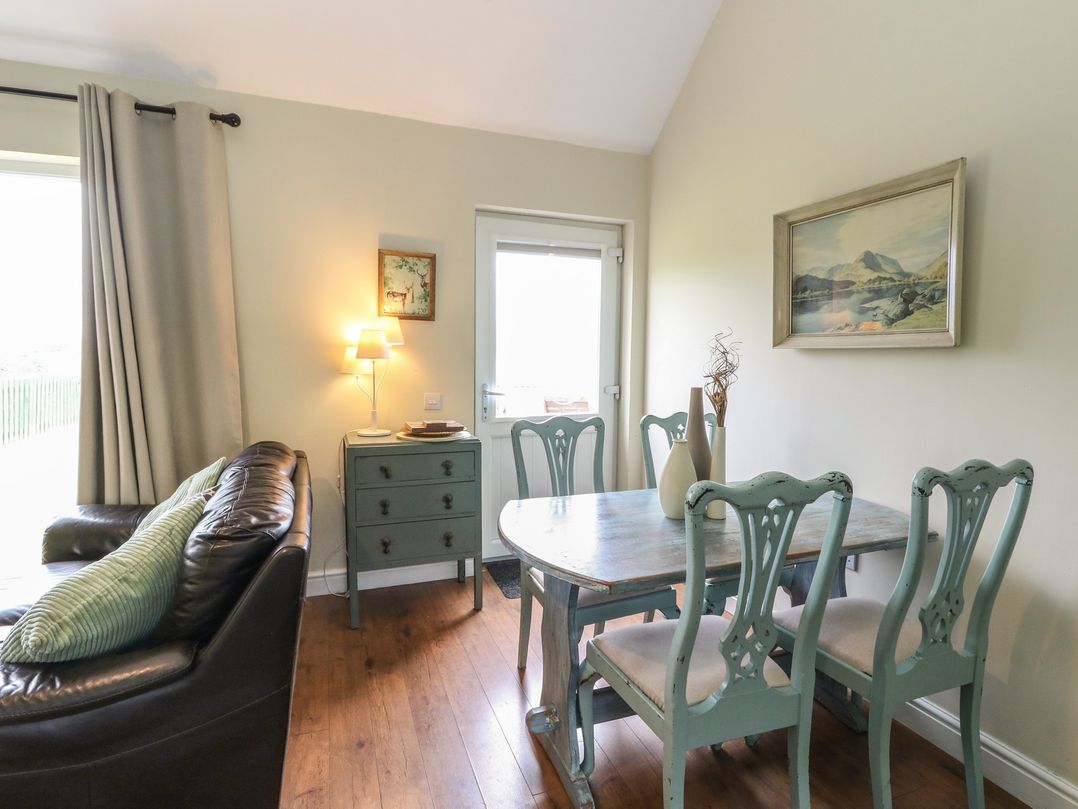 A dining room with a table and chairs at Driftwood Cottage, Craignure, Isle Of Mull