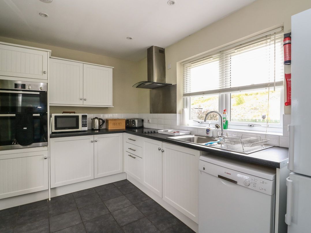 A kitchen with appliances and cabinets at Driftwood Cottage Craignure Isle Of Mull